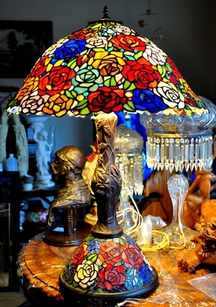 Tiffany style table lamp with a huge shade of roses of several colors