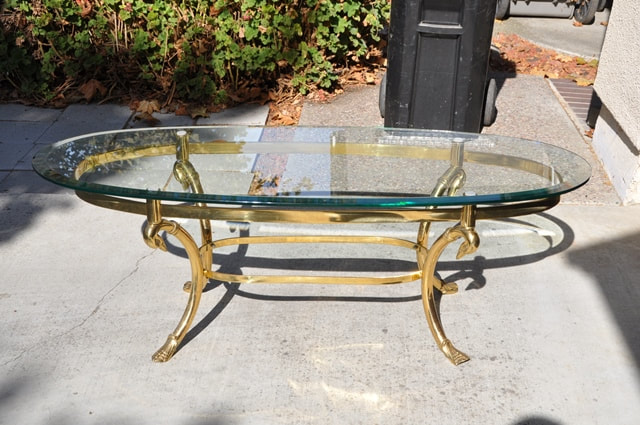 Hollywood Regency style oval glass top coffee table with brass